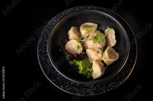top view on ready russian pelmeni served with salad in bowl