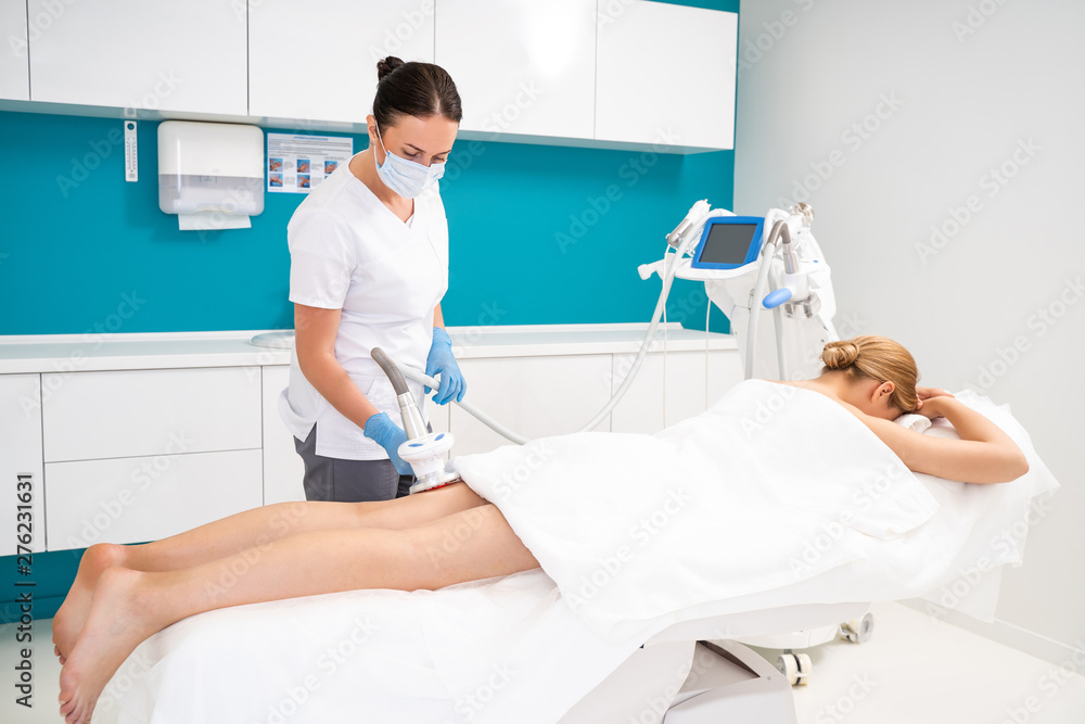 Obraz premium Massagist making vacuum roller massage with new apparatus for female client