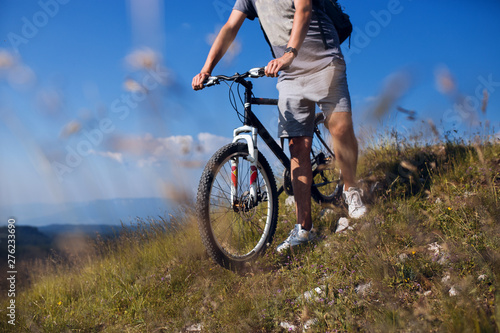 Unrecognizable man with bicycle on mountain