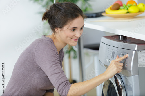 woman pressing button to start her washing machine