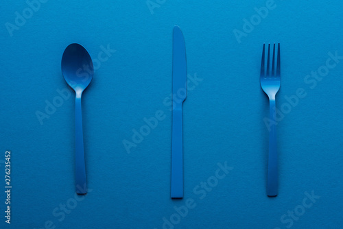 blue plastic spoon  knife and fork on blue background
