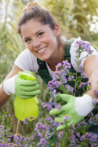 woman spraying flowers in the garden
