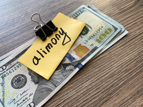 Payments alimony. Pile Dollars with sign alimony and money. Divorce and separation concept. photo