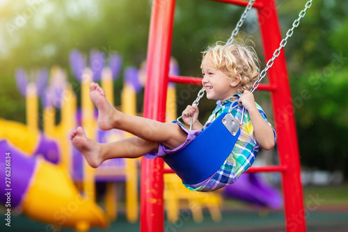 Child on playground. swing Kids play outdoor. photo