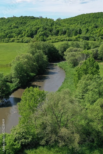 Aerial view of peacefully flowing slow river arm surrounded by trees and meadows. Location recreational area Motova near Zvolen, central Slovakia