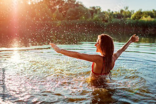 Photography Young woman in bikini playing in water and making splash