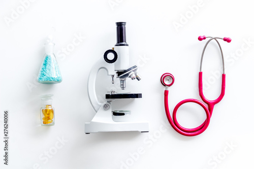 Desk of doctor in laboratory with microscope, stethoscope, test tube for research on white background top view