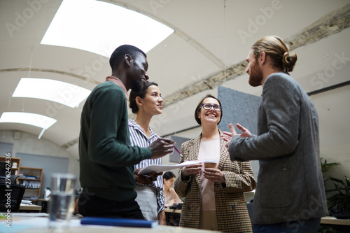 Photography Low angle view at multi -ethnic group of business people laughing happily while