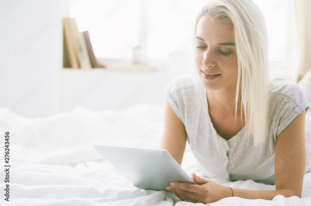 Girl holding digital tablet with blank screen and smiling at camera in bedroom Girl holding digital tablet with blank screen and smiling at camera in bedroom