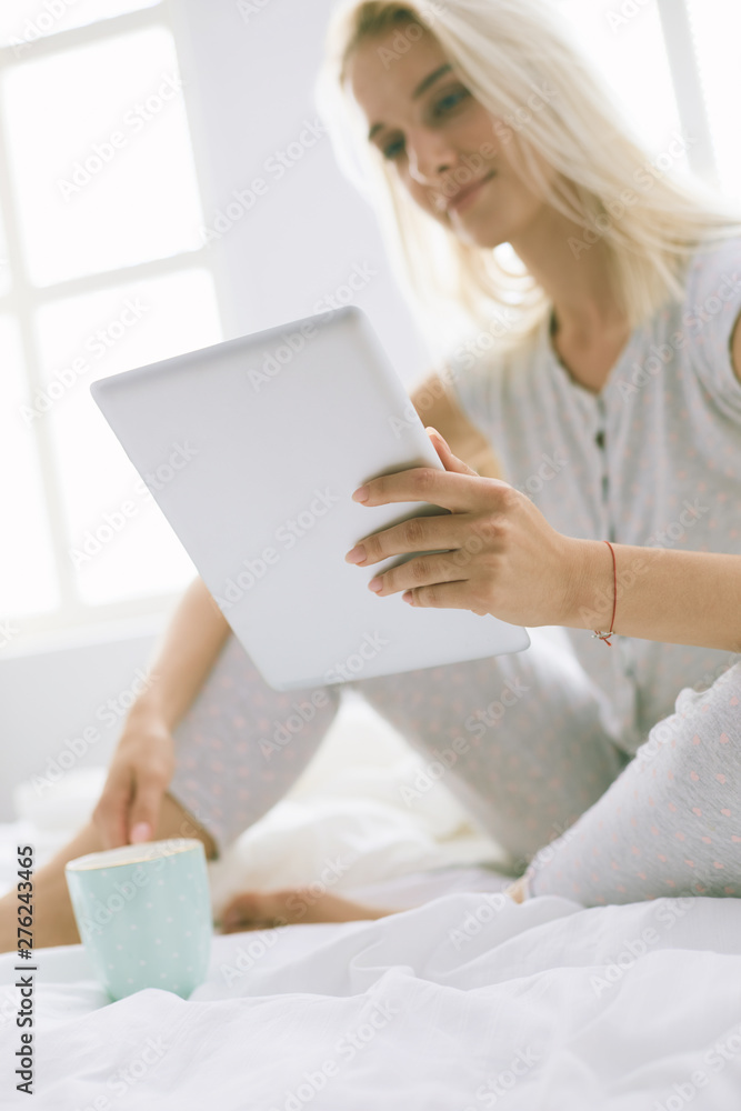 Girl holding digital tablet with blank screen and smiling at camera in bedroom Girl holding digital tablet with blank screen and smiling at camera in bedroom