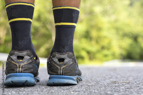 Man runner feet on road in Park workout wellness soft focus and focus close up on shoe