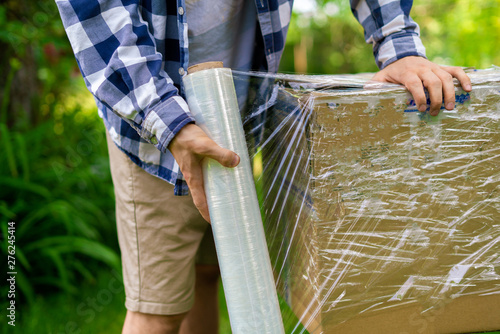 Fotografie stretch wrap roll, man packing the box for shipping