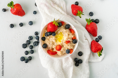 healthy breakfast with oatmeal porridge with starwberry and blueberry in a bowls photo