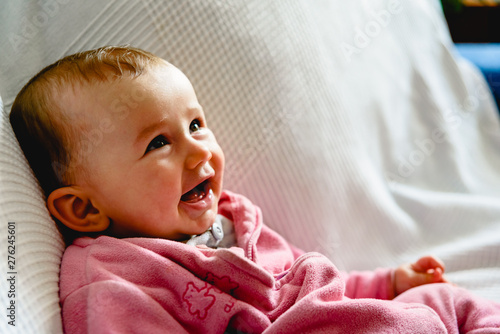 Adorable funny baby girl smiling with pink pajamas.