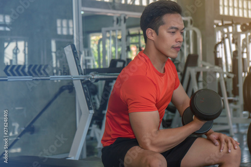 male having exercise lifting dumbbell in gym © Mongkolchon