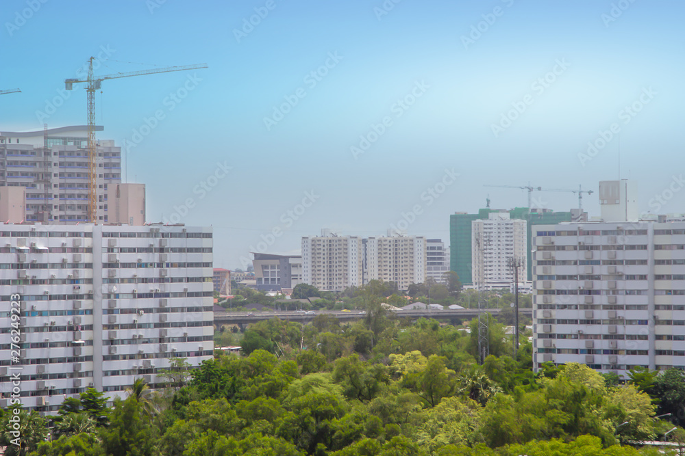 Large site including several cranes working for construction crews to work on high ground heavy industry and safety concept over blurred natural background on a building complex, with clear blue sky