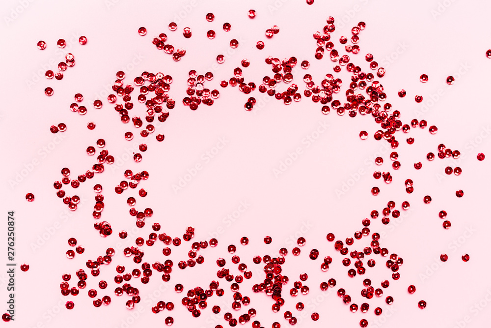Red confetti on pink background. Top view, flat lay, mockup, overhead. Copy space for text. Bright and festive holiday background. For Christmas, New year, Valentines Day, Birthday, holiday background