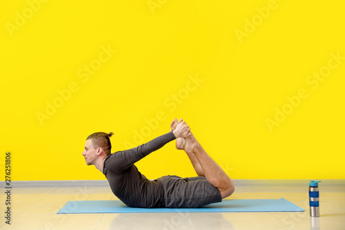 Sporty man practicing yoga ...