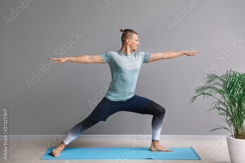 Sporty man practicing yoga ...