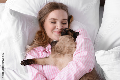 Young woman with cute Thai cat in bedroom