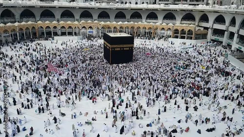Muslim pilgrim umrah or hajj revolving circling tawaf around holy Kaaba inside masjidil haram mecca saudi arabia