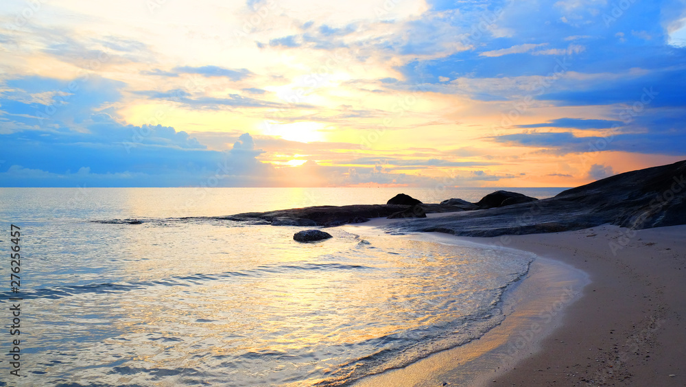 Obraz premium Sunrise on pastel color cloud sky at tropical sand beach with reef in the morning on rain season.