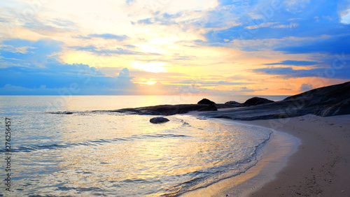 Sunrise on pastel color cloud sky at tropical sand beach with reef in the morning on rain season.
