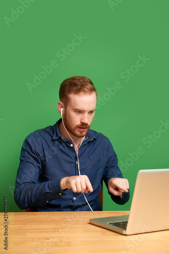 Handsome young Irish man explaining details of project when video caling his business parner photo