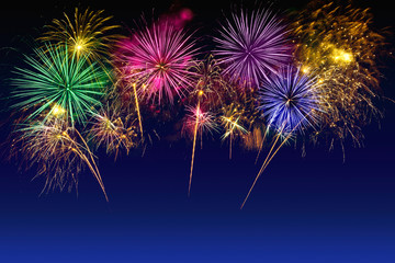 Beautiful colorful fireworks burst in the dark sky, long exposure shot of pyrotechnics. Colorful fireworks celebration on the twilight sky.