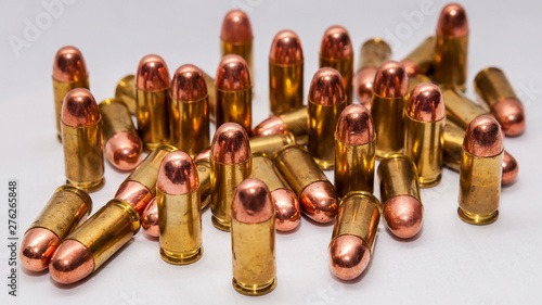 A group of 45 caliber full metal jacket bullets on a white background