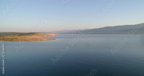 Boats on the adriatic sea, aerial, drone shot, away from fishing boat, at the mediterranean ocean, on Krk island, at sunrise, on a sunny, summer morning.in Croatia