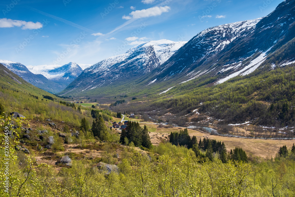 Spring landscape mountain valley with snow covered peaks in Norway