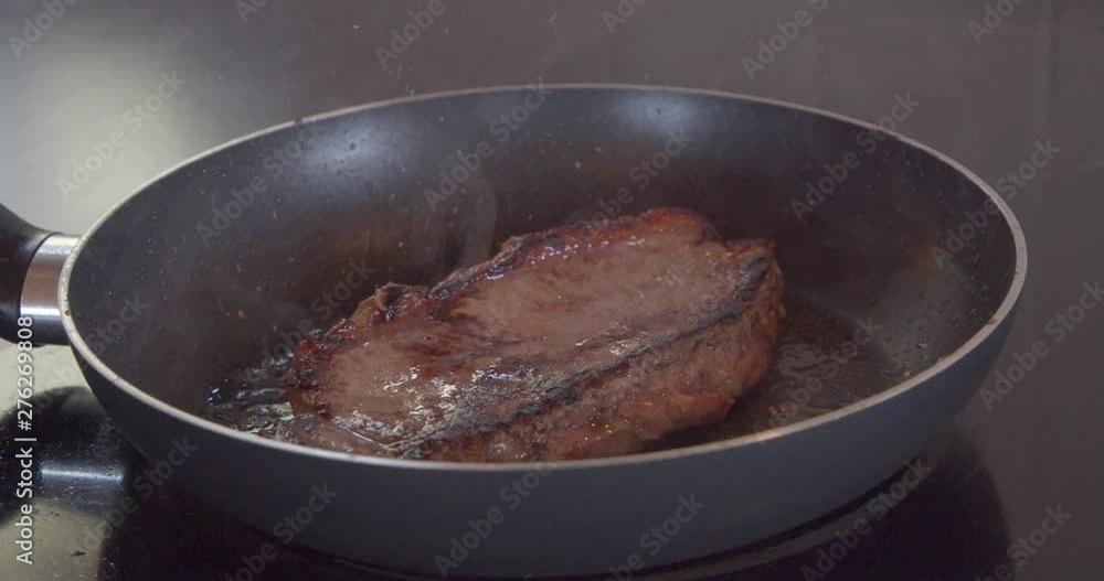 Steak frying in a pan getting moved around in butter Steak frying in a pan getting moved around in butter