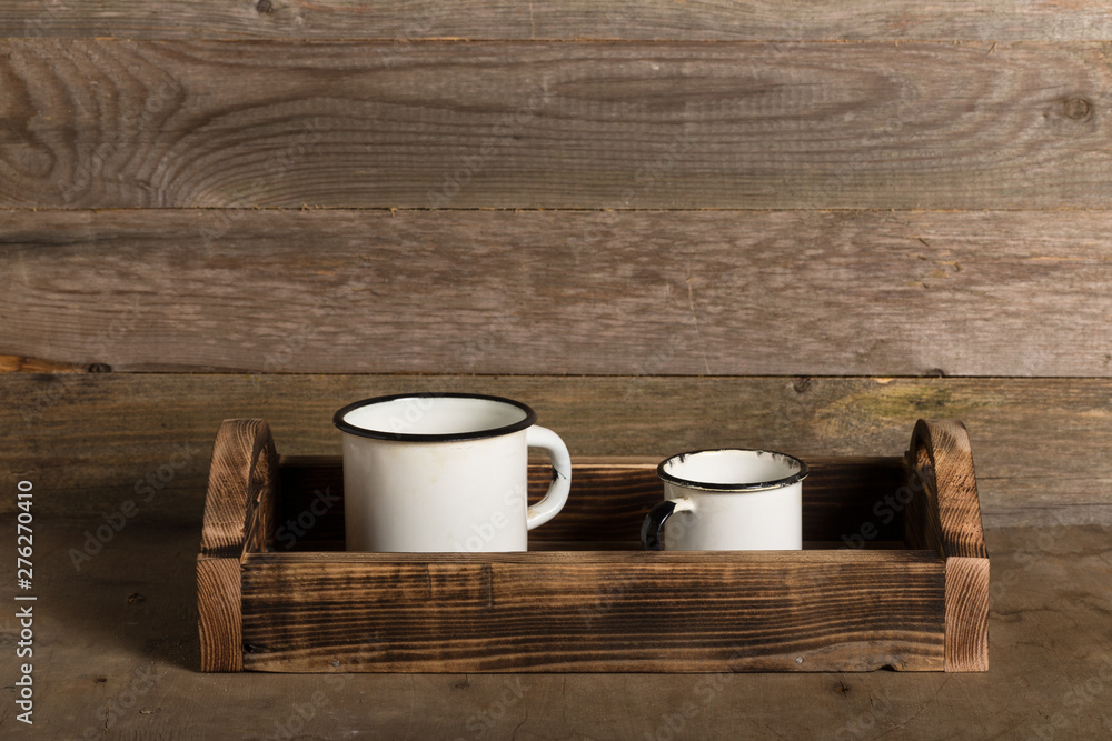 Old metal enamelware and handmade wooden box on the retro table Old metal enamelware and handmade wooden box on the retro table