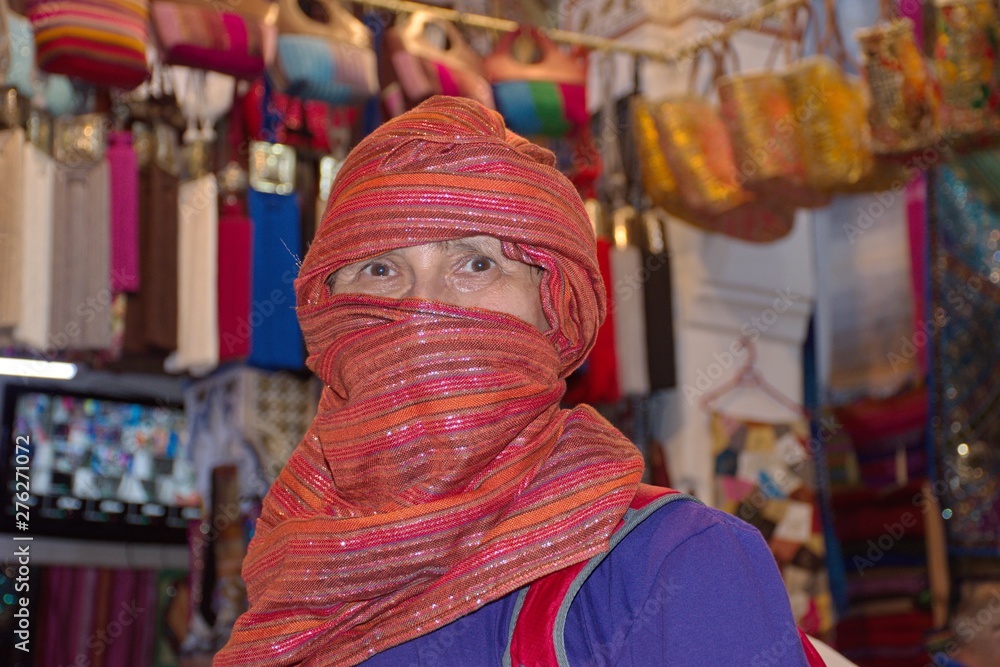 Portrait of a woman wearing traditional turban in traditional shop in Morocco