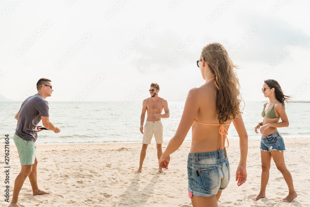 Group of friends enjoying playing beach game together Group of friends enjoying playing beach game together
