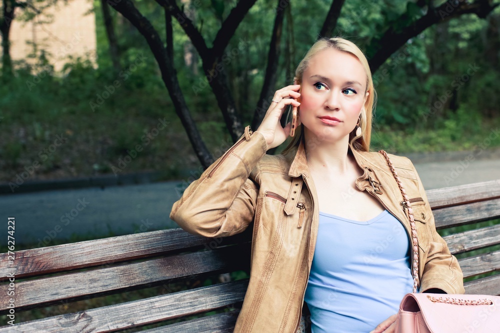Blonde woman in casual clothes tolking on the phone with a serious face. Blonde woman in casual clothes tolking on the phone with a serious face.