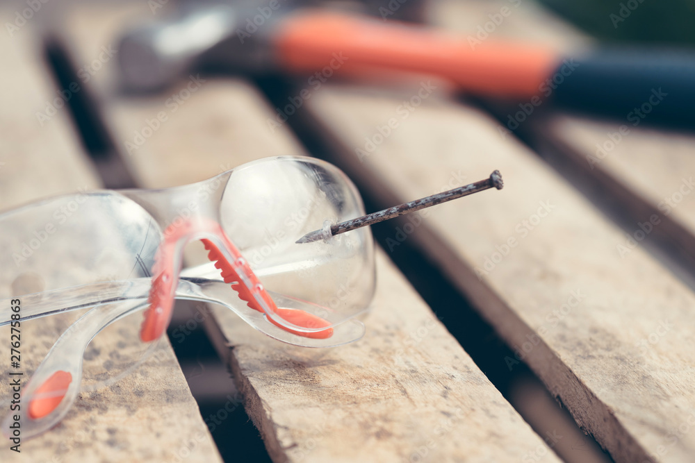 broken safety glasses, nail and hammer, concept of an accident at work. broken safety glasses, nail and hammer, concept of an accident at work.
