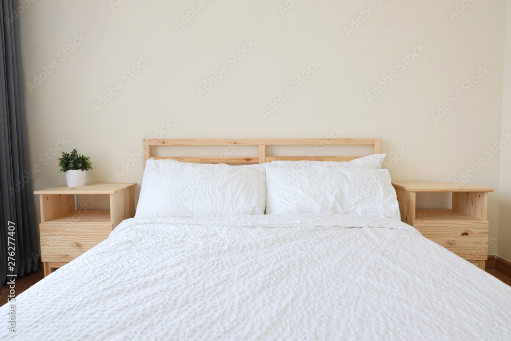 front view of new modern white wooden bed in white bedroom with soft and clear light, top copy space