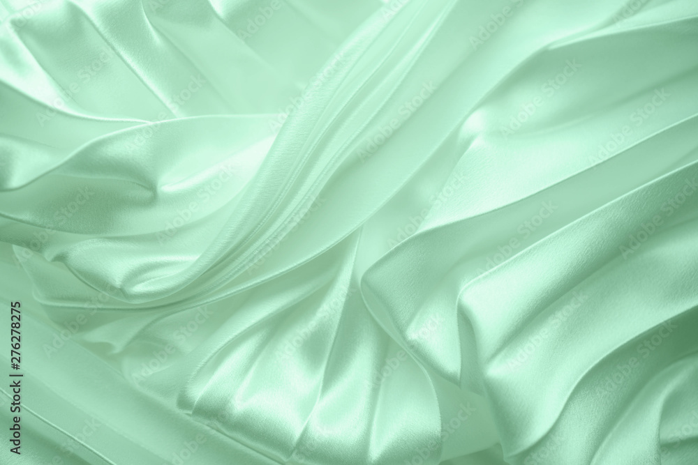 Neo mint color soft satin folded fabric background texture. Close up of ripples on silk fabric. Neo mint color 2020 year concept. Soft cloth background Neo mint color soft satin folded fabric background texture. Close up of ripples on silk fabric. Neo mint color 2020 year concept. Soft cloth background