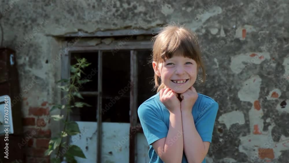 At the same time, a sad and joyfully funny girl on the background of the old abandoned house At the same time, a sad and joyfully funny girl on the background of the old abandoned house