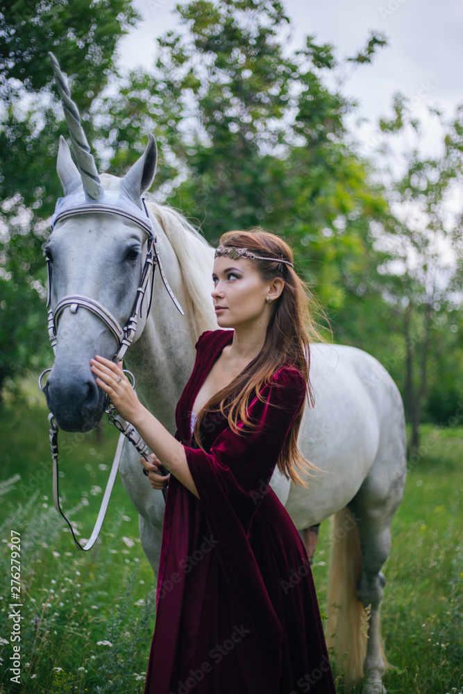 Obraz premium Beautiful girl in red medieval dress with unicorn. Fantasy. Woman Elf