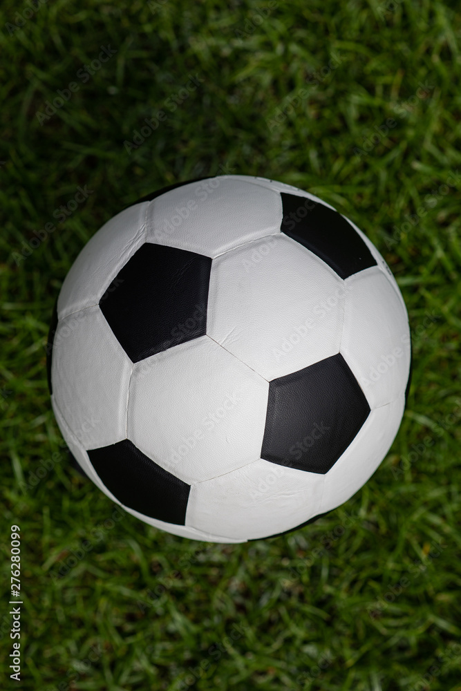 Obraz premium Football placed on a grass pitch in the afternoon awaiting for teams practicing.