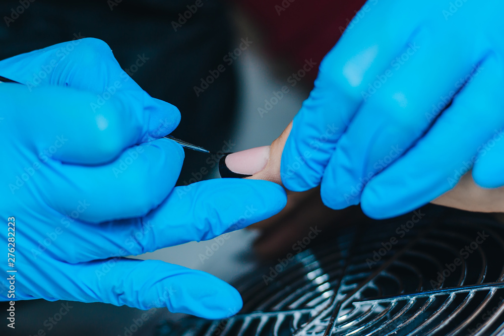 Manicurist. A girl with blue gloves makes a manicure. The process of manicure. Manicurist. A girl with blue gloves makes a manicure. The process of manicure.