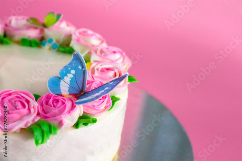Fototapeta Naklejka Na Ścianę i Meble -  Butter cream of Pink Roses decorated on vanilla pond cake on pink background with copy space served in Birthday Party and wedding. Delicious sweet bakery for someone you love.