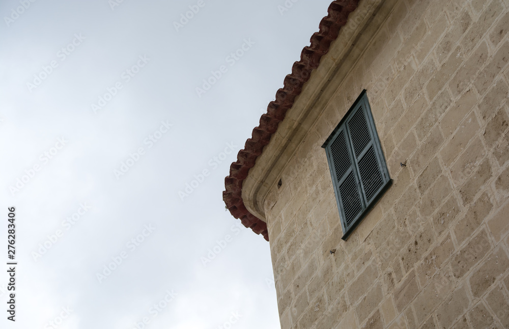 Top corner of a house with a window and louvres. Top corner of a house with a window and louvres.