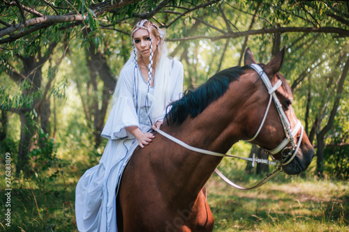 Dekoracja na wymiar  elf-girl-in-white-dress-with-brown-horse-in-the-forest-model-in-a-medieval-dress-with-pigtails