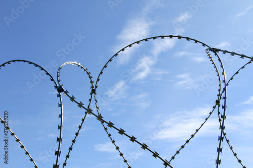 Barbed wire steel fence in the border zone