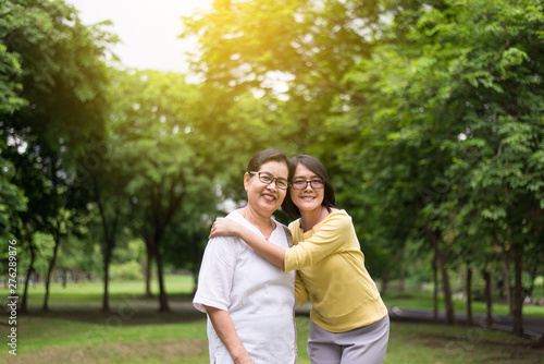 Portrait of middle aged asian female with daughter standing and hugging together outdoor,Happy and smiling,Positive thinking,Take care and support concept