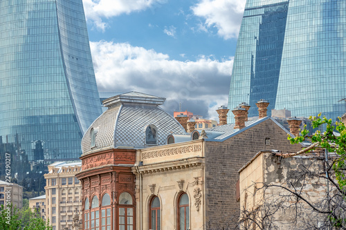 Street view from the narrow streets of Icherisheher old town of Baku,historical centrer with traditional houseson and view on modern Flame towers